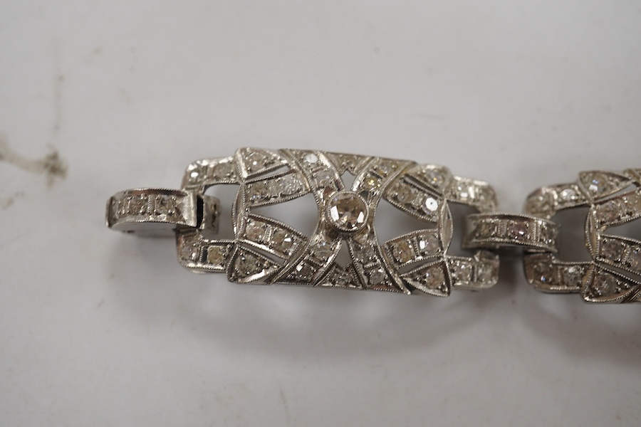 An early 20th century pierced platinum? and millegrain set diamond cluster bracelet, set with old round and eight cut stones, 17cm, gross weight 22.8 grams. Condition - fair to good